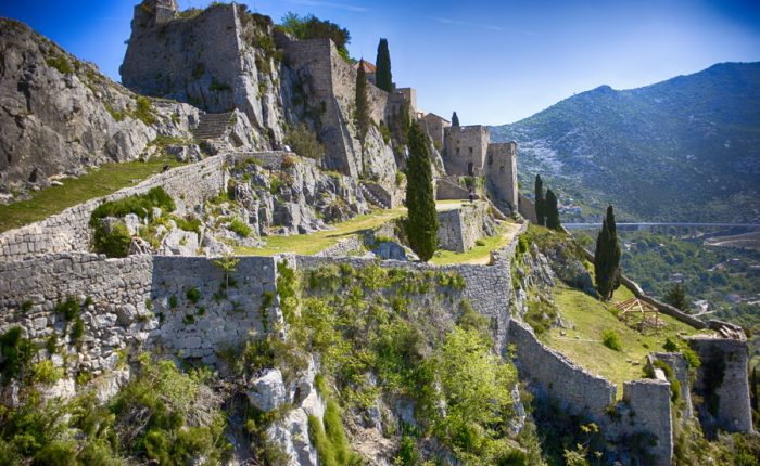 A majestic view of Klis Fortress, a historic fortress perched on a hilltop overlooking the surrounding landscape.