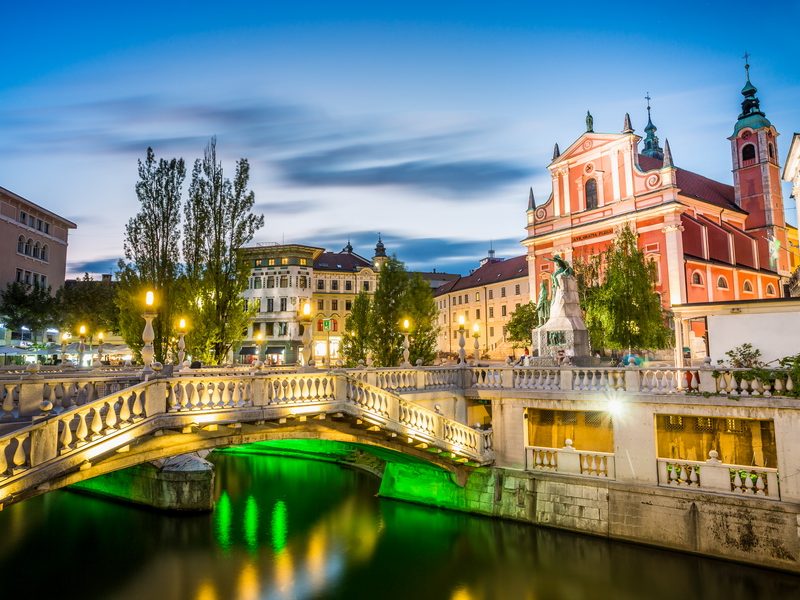 A night view of Ljubljana, Slovenia, with the Triple Bridge and Franciscan Church in the background.