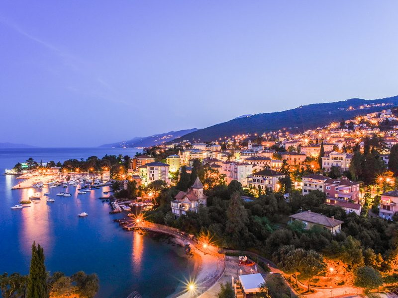 A picturesque evening view of Opatija, Croatia, showcasing the town's beautiful architecture and stunning natural surroundings.