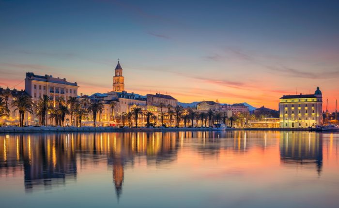 A picturesque image of Split's historic center and harbor, illuminated at dusk.