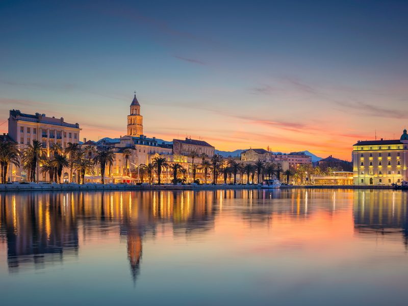 A picturesque image of Split's historic center and harbor, illuminated at dusk.