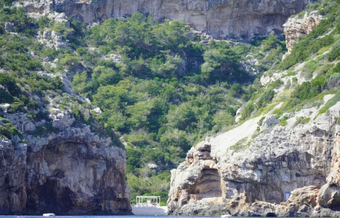 Secluded cove with lush Mediterranean vegetation and dramatic rocky cliffs on the island of Vis, Croatia - hidden natural wonder and serene escape in the Adriatic.