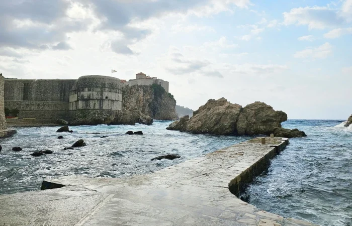 Dubrovnik’s West Pier and Fort Bokar, instantly recognizable as Blackwater Bay from Game of Thrones, with dramatic rocks and swirling Adriatic waves.