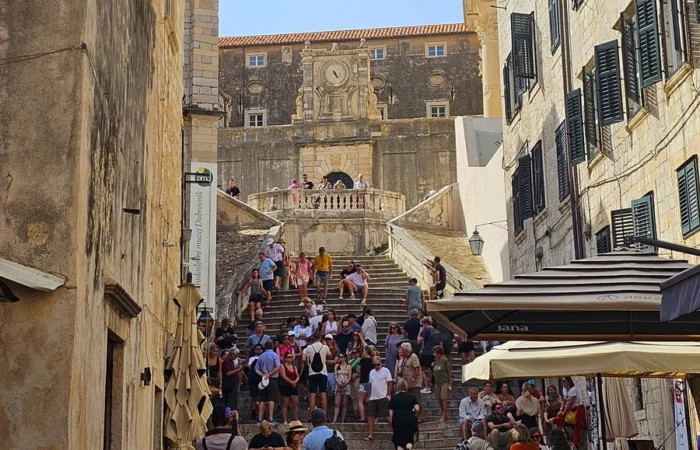 Crowds gather on Dubrovnik’s historic Jesuit Stairs, the real-life filming location of Cersei's Walk of Shame in Game of Thrones, beneath ornate Baroque buildings.
