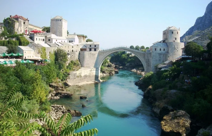 Frontal view of Mostar’s Stari Most (Old Bridge) with historic towers on both riverbanks, spanning the turquoise Neretva River, Bosnia and Herzegovina.