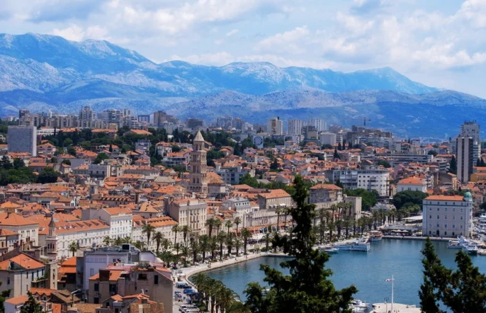 Panorama from Marjan hill of Split, Croatia, featuring the Riva promenade, the bell tower of St. Domnius Cathedral, and the Old Town lining the harbor with Dinaric Alps in the distance.