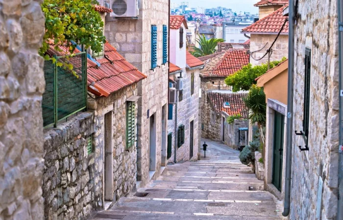 Steep stone alley with shuttered windows and tile roofs in Varoš, the traditional old town neighborhood of Split, Croatia.