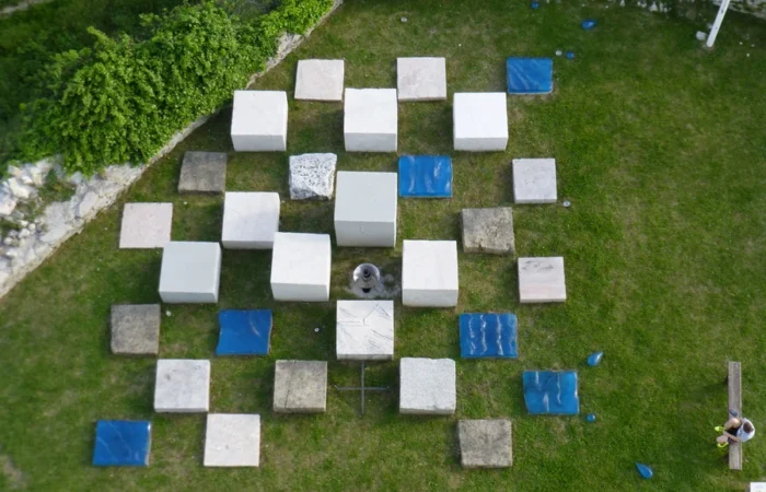 Aerial view of a contemporary stone and blue-tile art installation on the grass inside Medvedgrad Fortress above Zagreb.